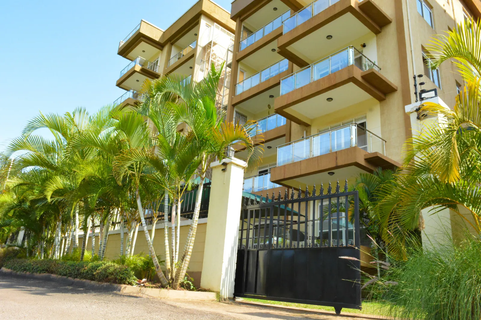 Balcony view of swimming pool and palm trees at Exclusive Kololo Address apartment in KololoIii, Kampala, Uganda